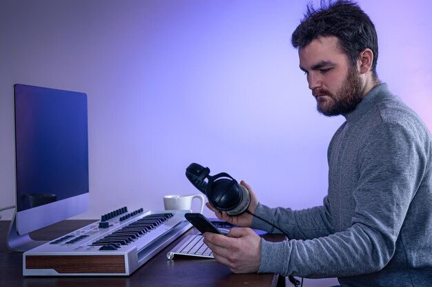 Male musician creates music using computer and keyboard musician workplace