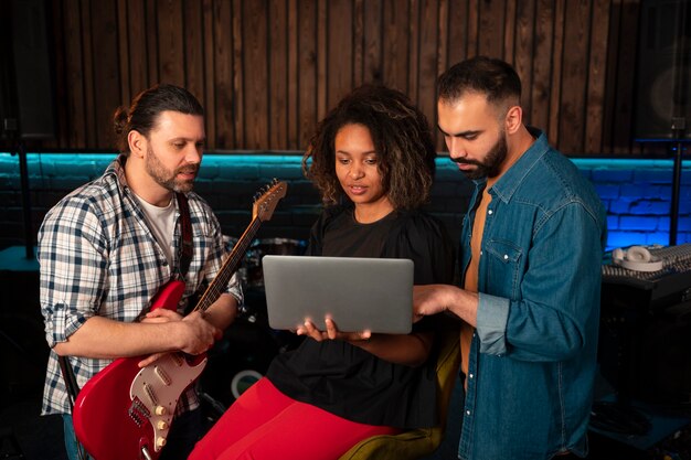 Medium shot musicians working with laptop